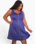 A woman modeling a sleeveless, scoop-neck babydoll dress in a medium purple color, featuring a button-down front and a matching fabric tie at the waist, set against a plain white background.