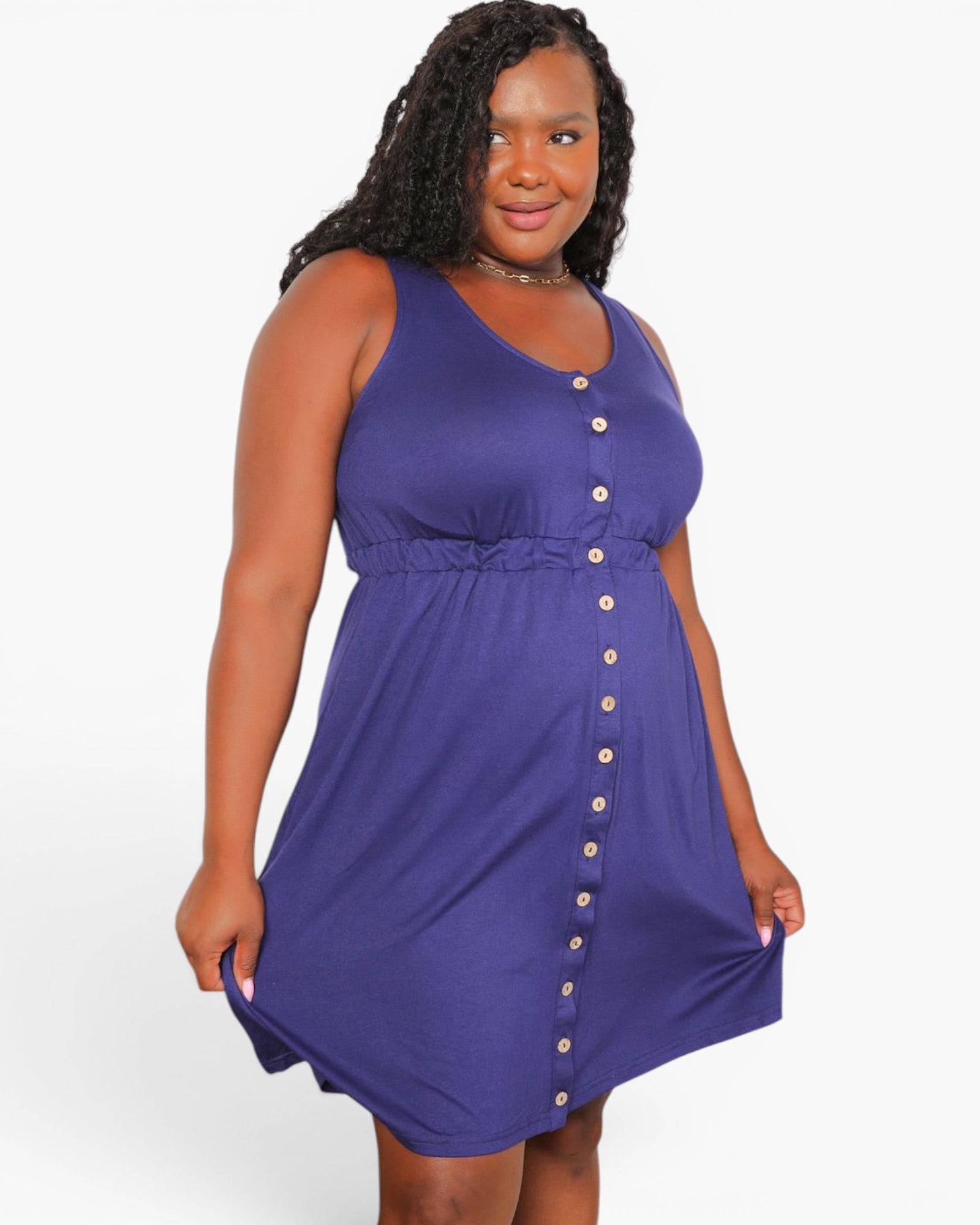 A woman modeling a sleeveless purple A-line dress with a button-down front and a gathered waist, set against a plain white studio background.