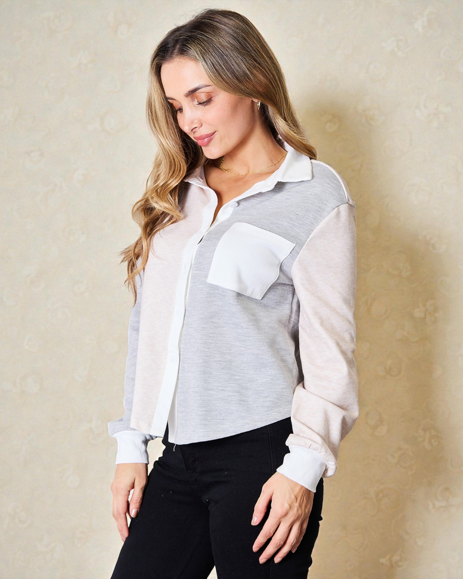 Woman wearing a light gray and white patterned shirt against a beige background