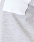 Close-up of a light heather gray knit fabric with a white folded collar or pocket edge visible at the top.
