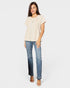 Woman wearing a beige blouse and blue jeans on a white background