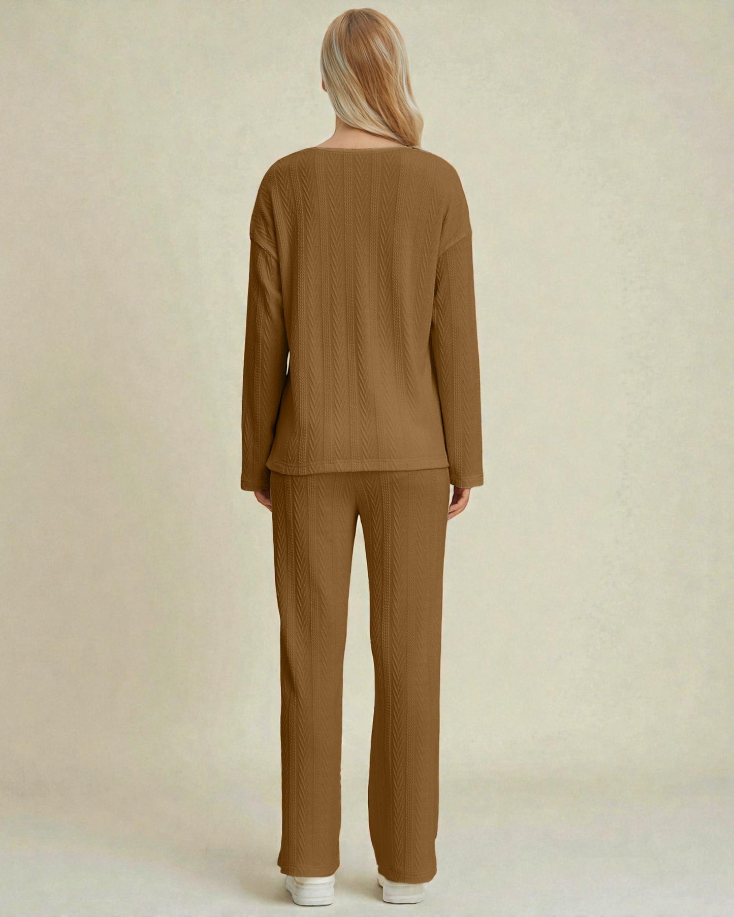Woman wearing a brown ribbed sweater and pants set on a beige background
