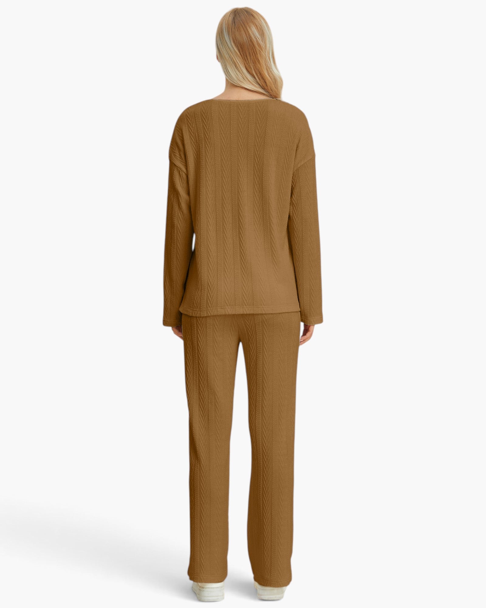 A woman viewed from the back wearing a matching ribbed knit two-piece set in a warm camel brown color, consisting of a long-sleeve top and wide-leg pants, against a plain white background.