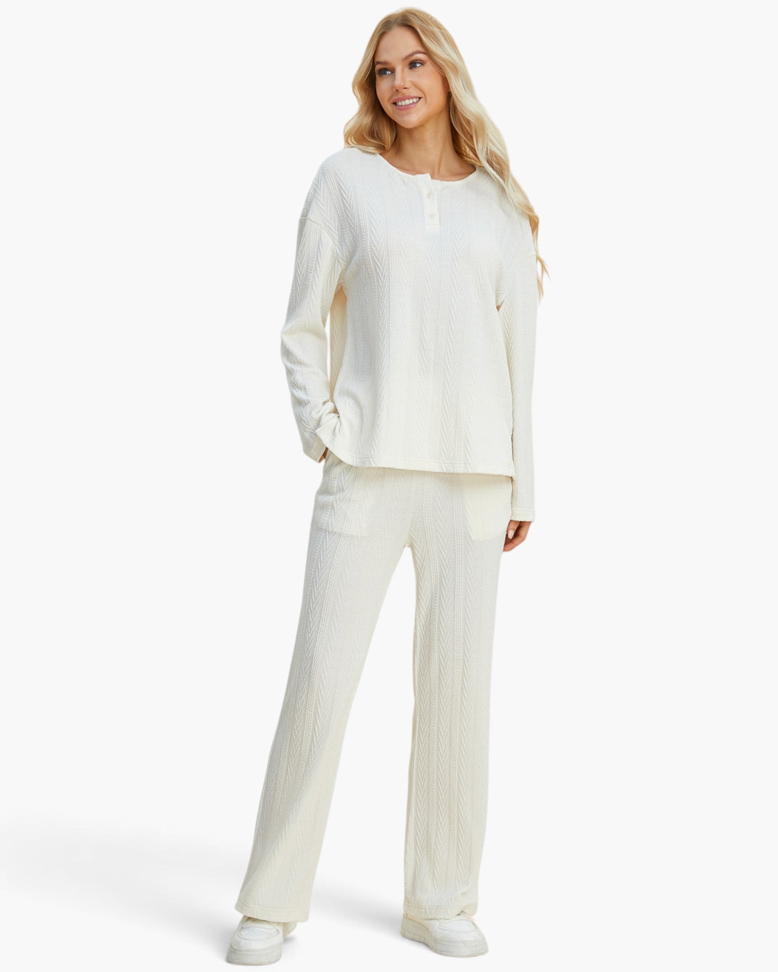 A woman modeling a matching two-piece loungewear set in an off-white color, featuring a long-sleeve henley top and wide-leg pants, set against a plain light gray background.
