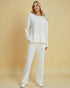 Woman wearing a white outfit on a beige background