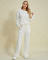 Woman wearing a white outfit on a beige background