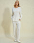 Woman wearing a white outfit against a light beige background