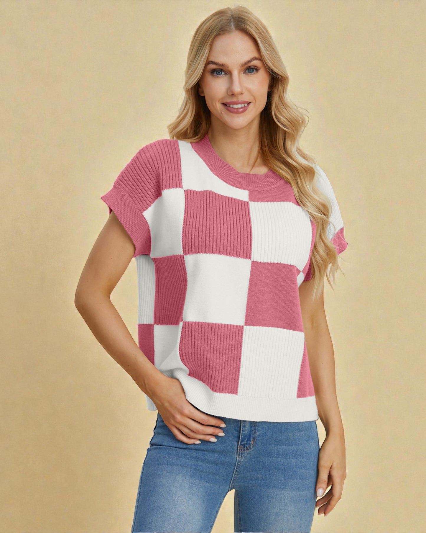 Woman wearing a pink and white checkered top with blue jeans on a beige background