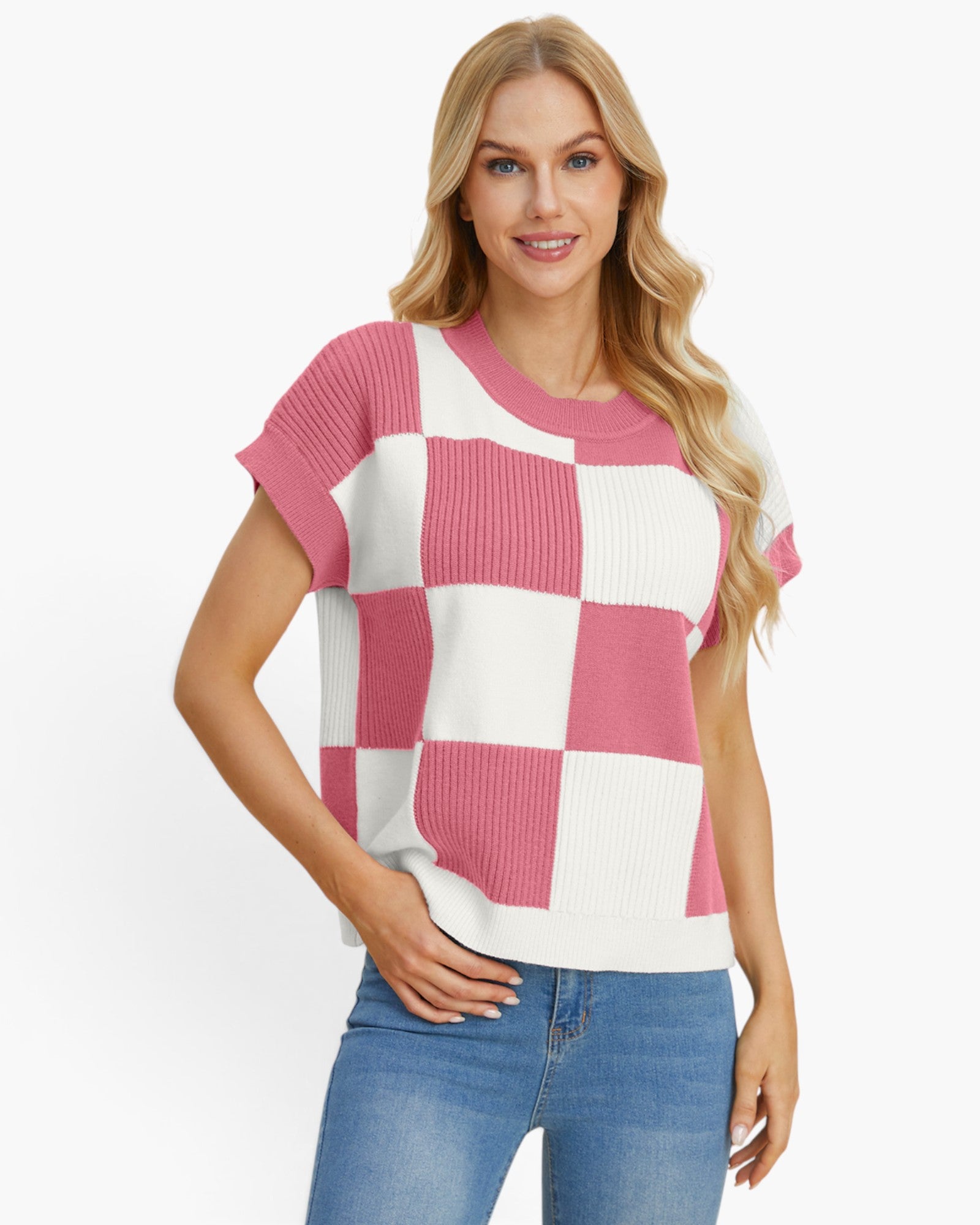 A woman modeling a short-sleeve knit top with a pink and white checkerboard pattern, paired with blue jeans, against a plain white background.