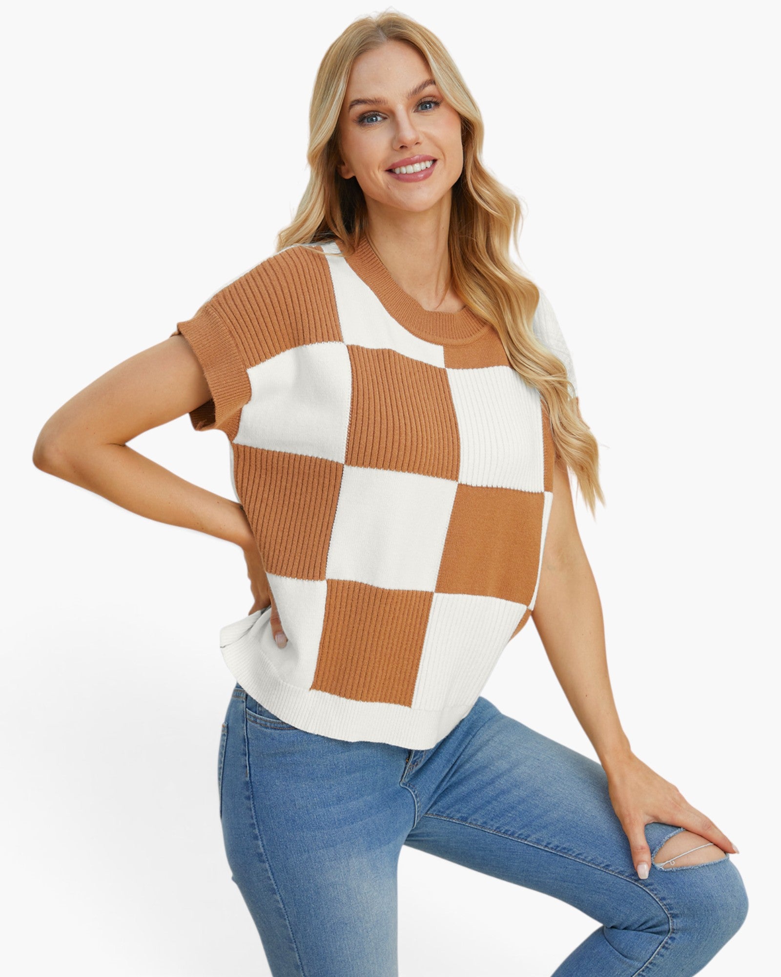 A woman modeling a short-sleeve knit top with a brown and off-white checkerboard pattern, paired with blue jeans, against a plain white background.