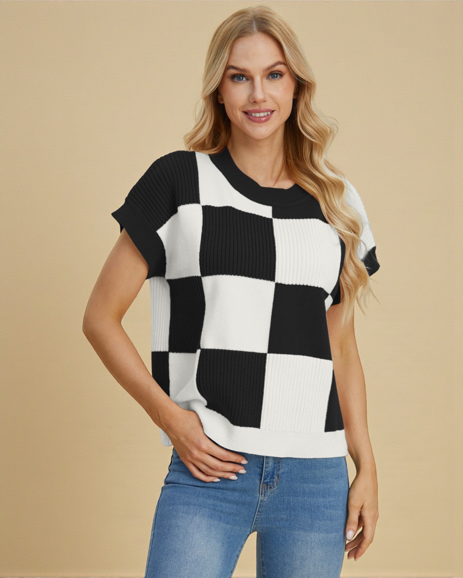 Woman wearing a black and white checkered sweater with blue jeans on a beige background