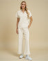Woman wearing a white outfit with a beige background