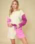 Woman wearing a two-tone sweater and shorts set on a beige background