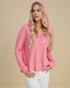 Woman wearing a pink hoodie with a beige background