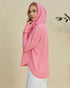 Woman wearing a pink hooded sweater against a beige background