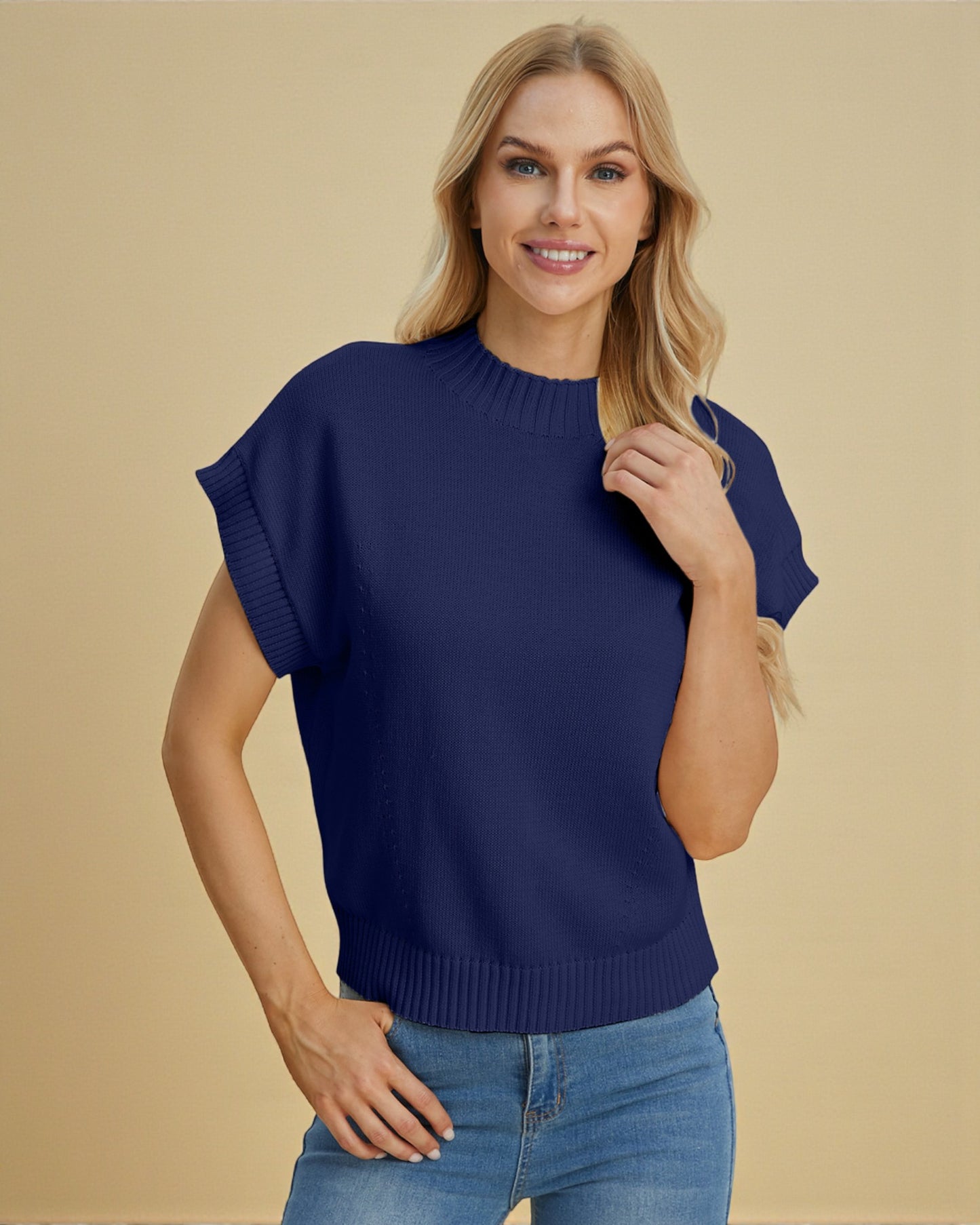 Woman wearing a blue sweater and jeans against a beige background