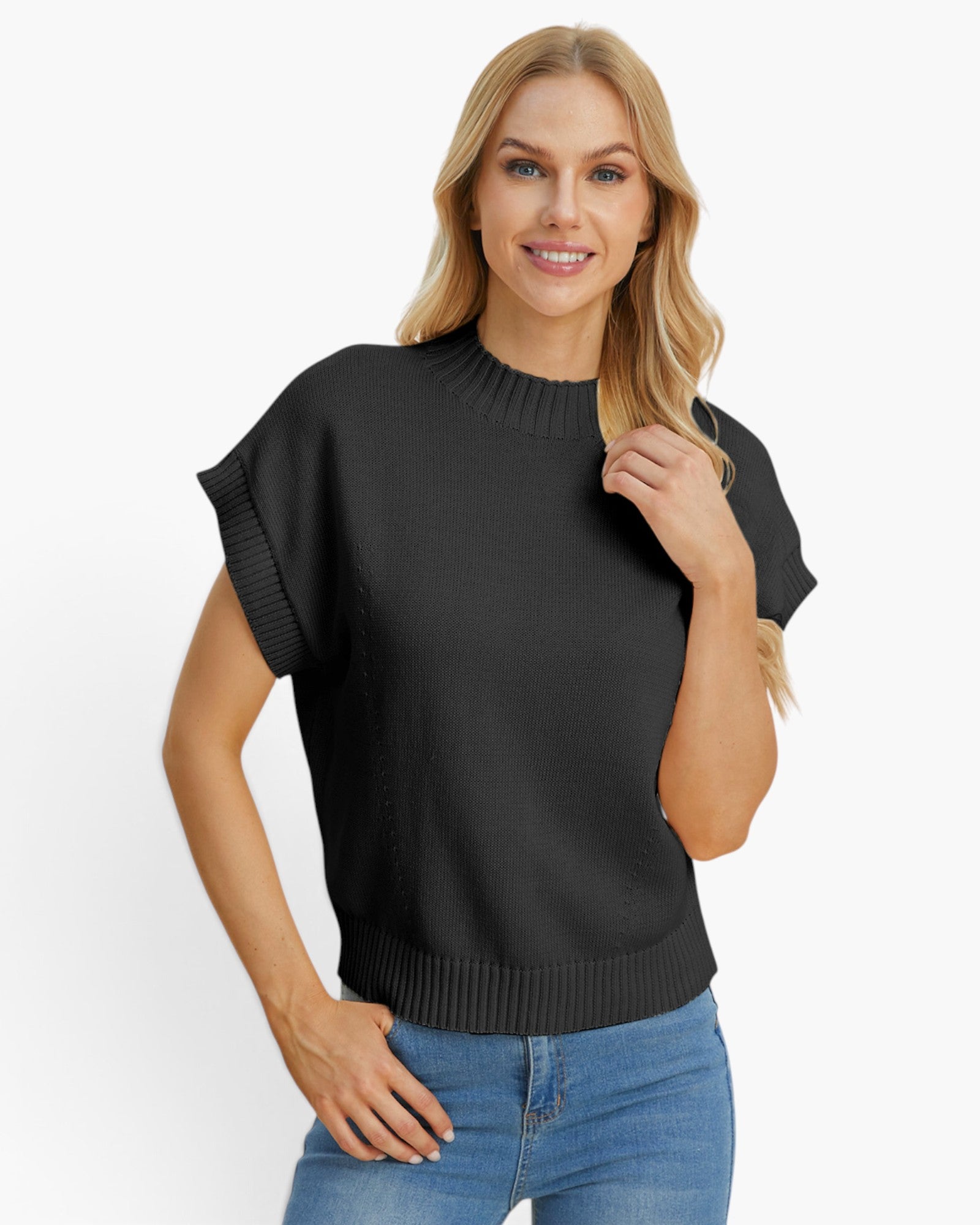 A woman modeling a black short-sleeve knit sweater with ribbed trim, paired with blue jeans, against a plain white studio background.