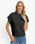 A woman modeling a black short-sleeve knit sweater with ribbed trim, paired with blue jeans, against a plain white studio background.