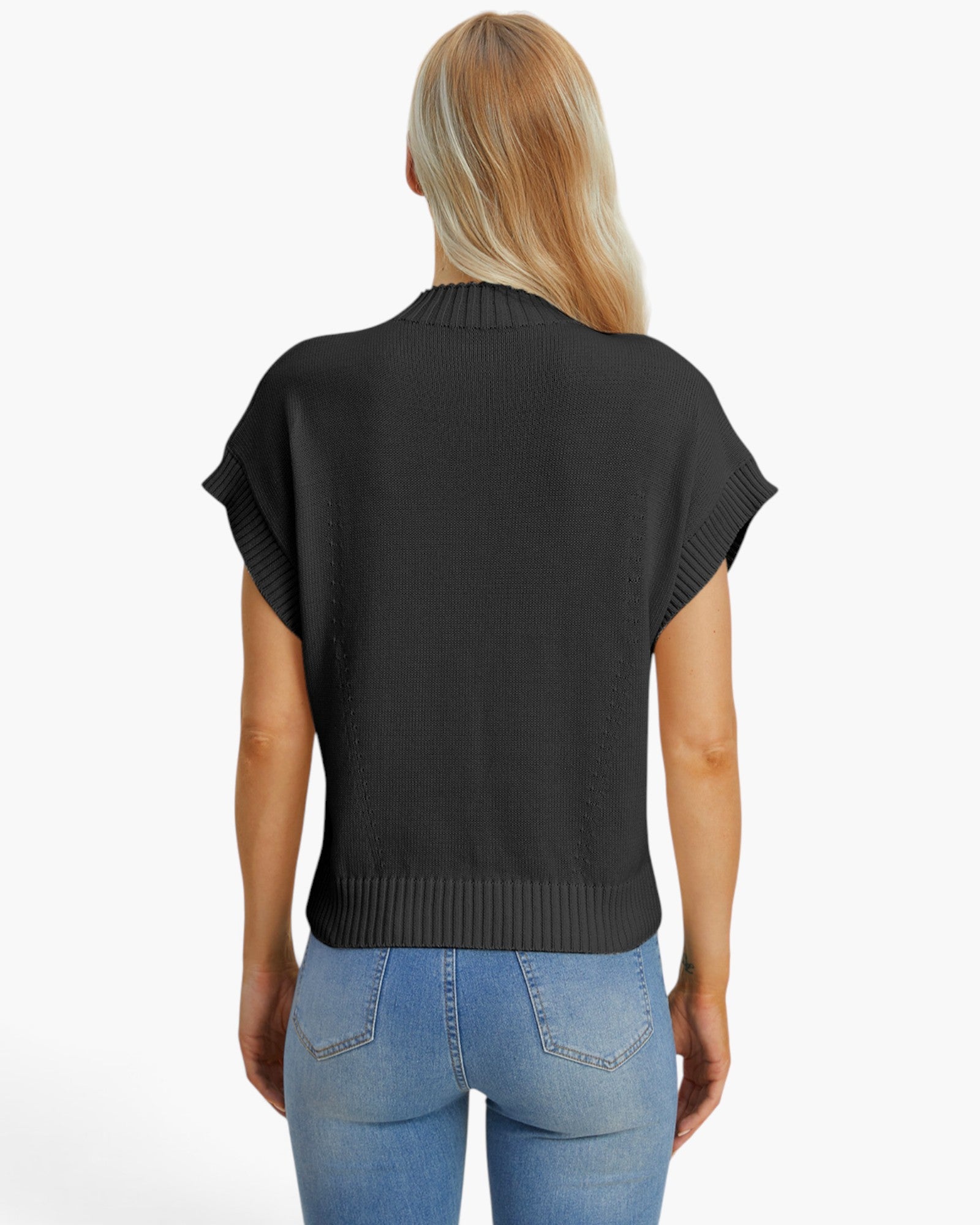 A woman viewed from the back wearing a black short-sleeve knit top with ribbed trim and light blue jeans, against a plain white background.