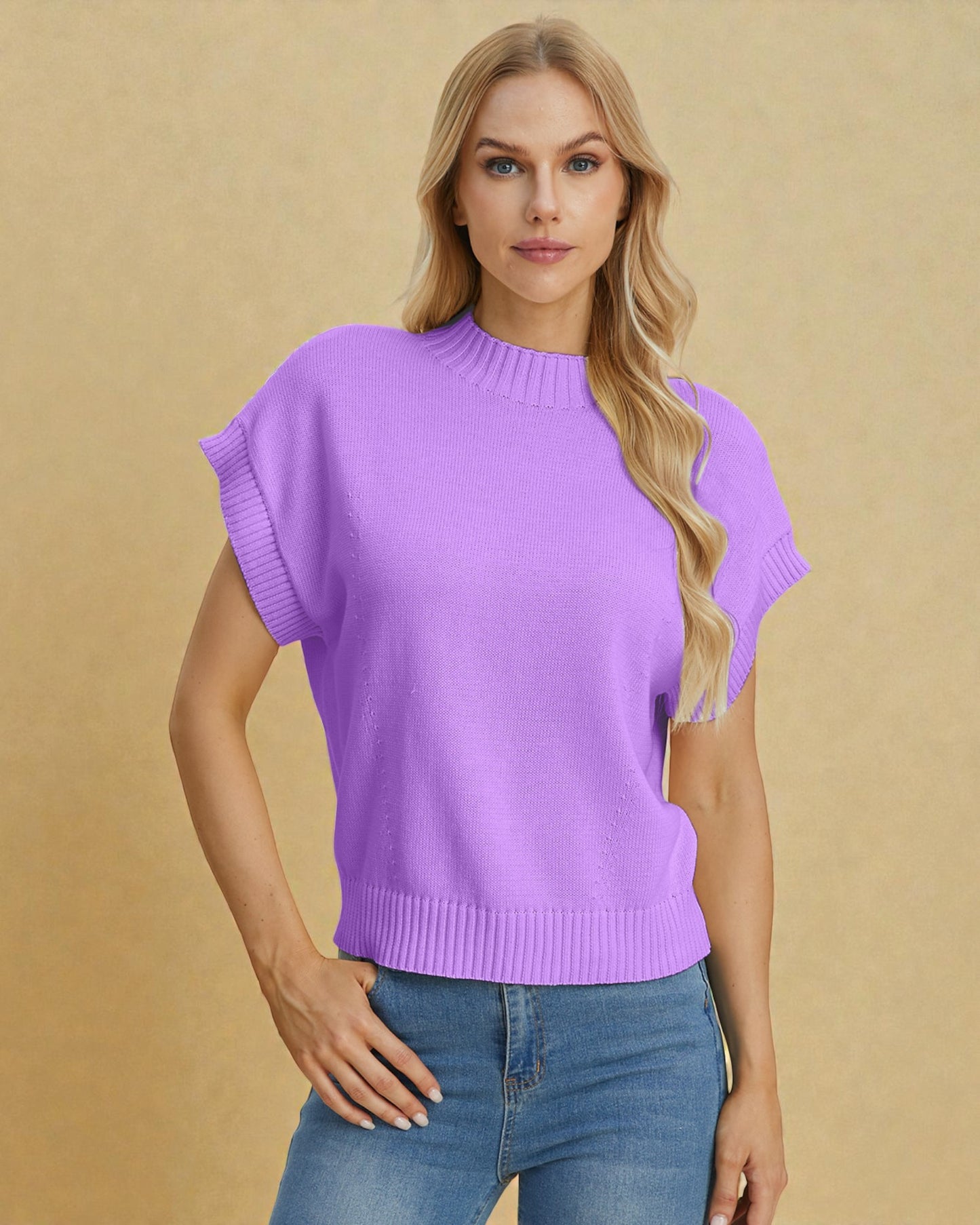 Woman wearing a purple sweater and blue jeans against a beige background