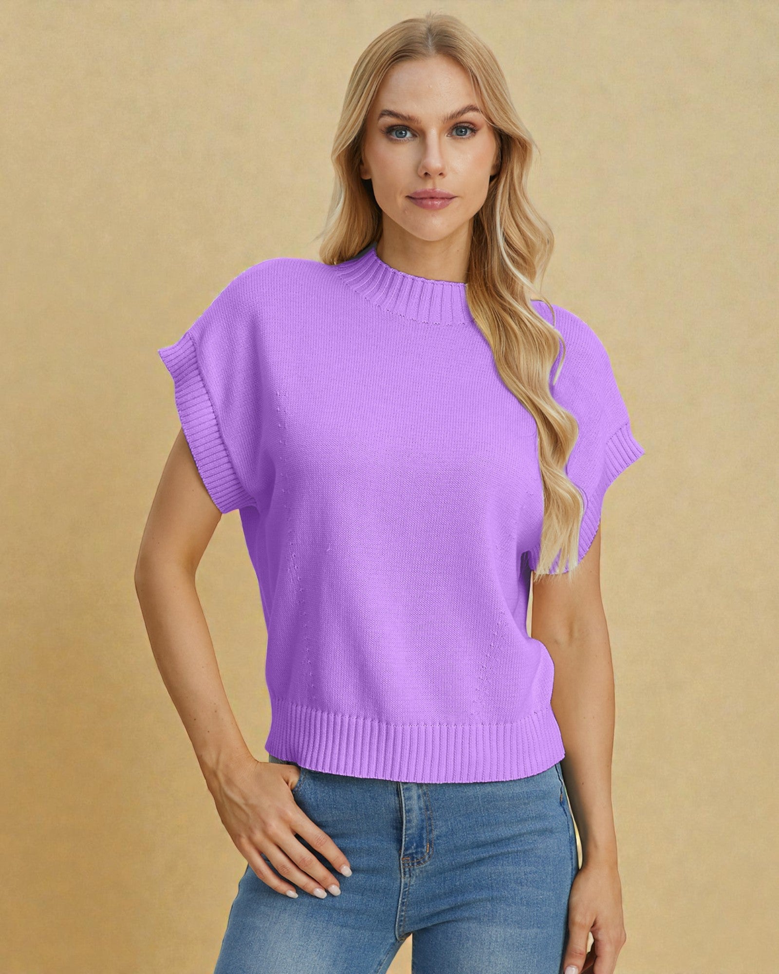 Woman wearing a purple sweater and blue jeans against a beige background