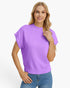 A woman modeling a short-sleeve knit sweater in a solid light purple color, paired with blue jeans, against a clean white background.