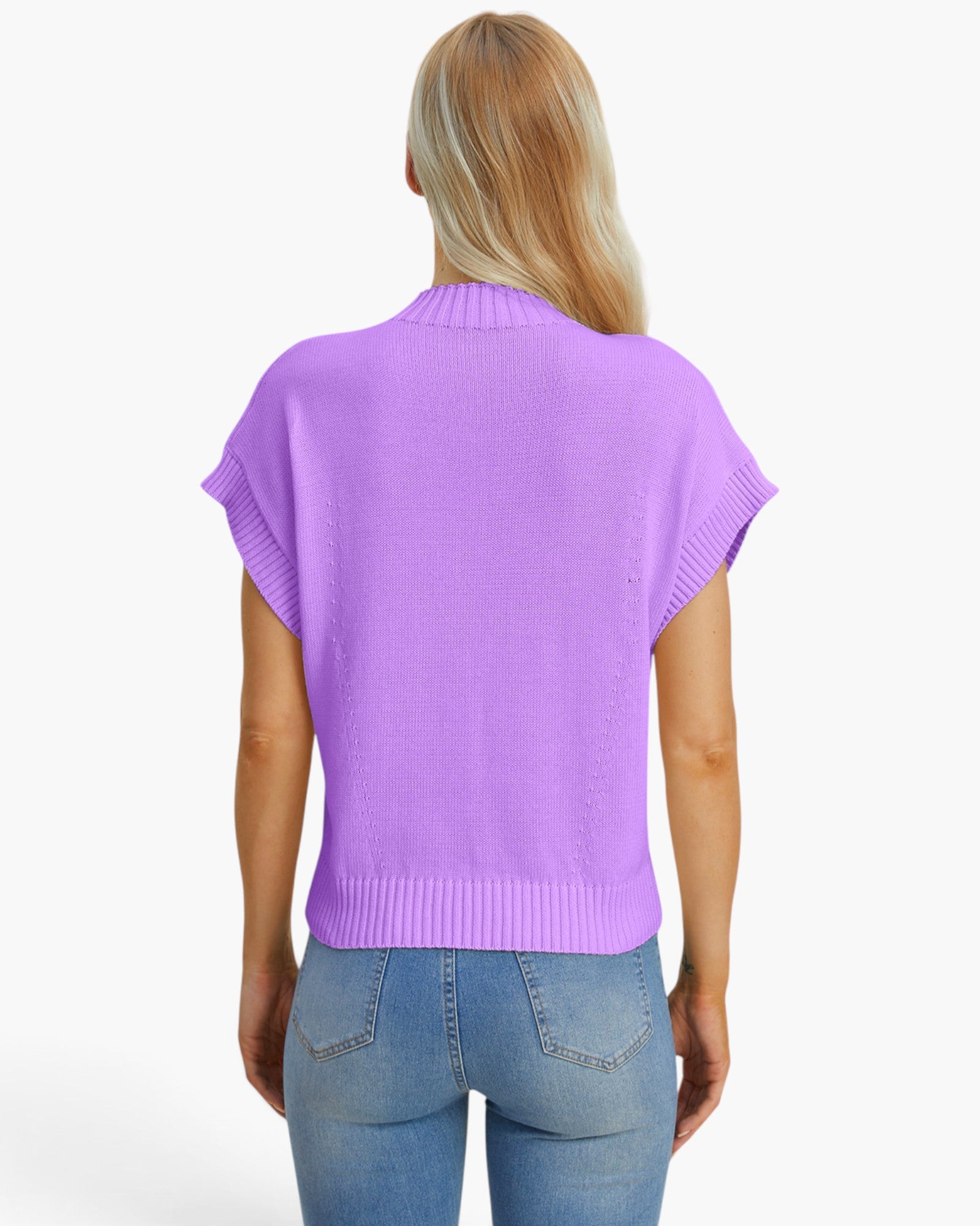 A woman viewed from the back wearing a light purple knit sweater with short dolman sleeves and light blue jeans, set against a plain white studio background.
