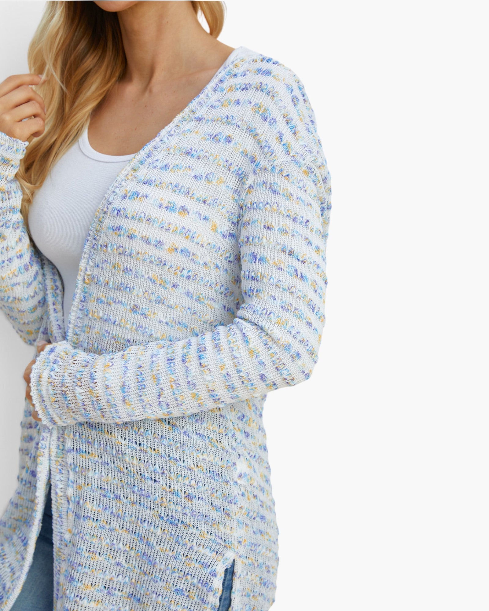 A woman wearing a long open-front knit cardigan with a marled blue, white, and light yellow pattern over a white tank top, shown against a plain white background.