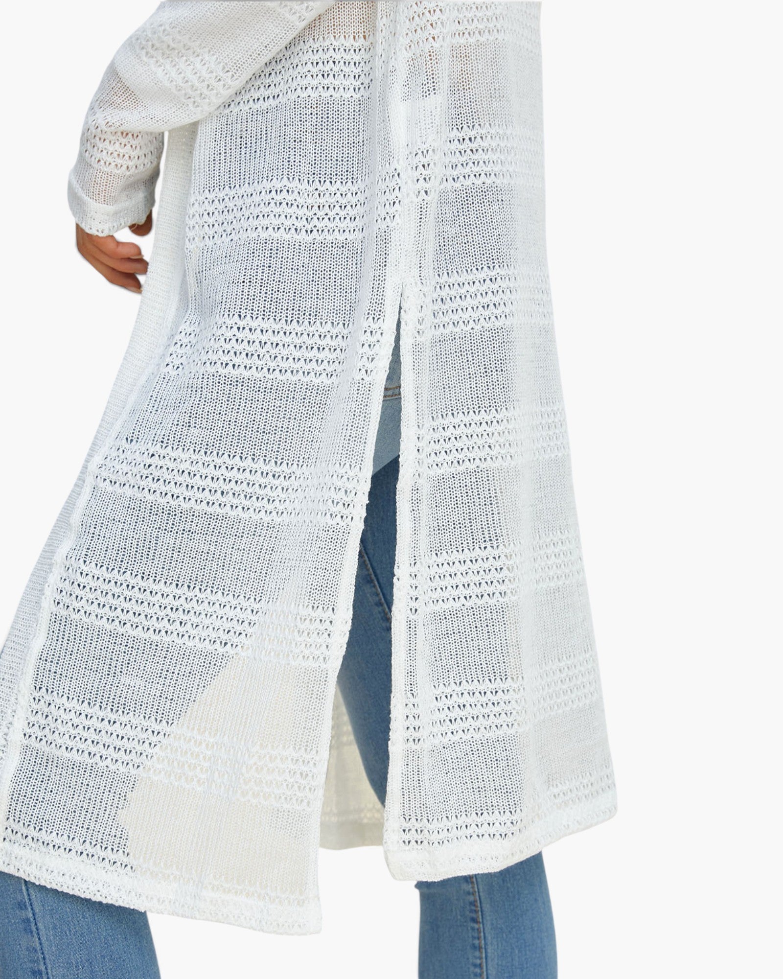A white open-knit long cardigan or duster with textured horizontal stripes, shown worn over blue jeans against a plain white background.