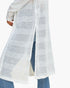 A white open-knit long cardigan or duster with textured horizontal stripes, shown worn over blue jeans against a plain white background.