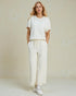 Woman wearing a white outfit with a plain background