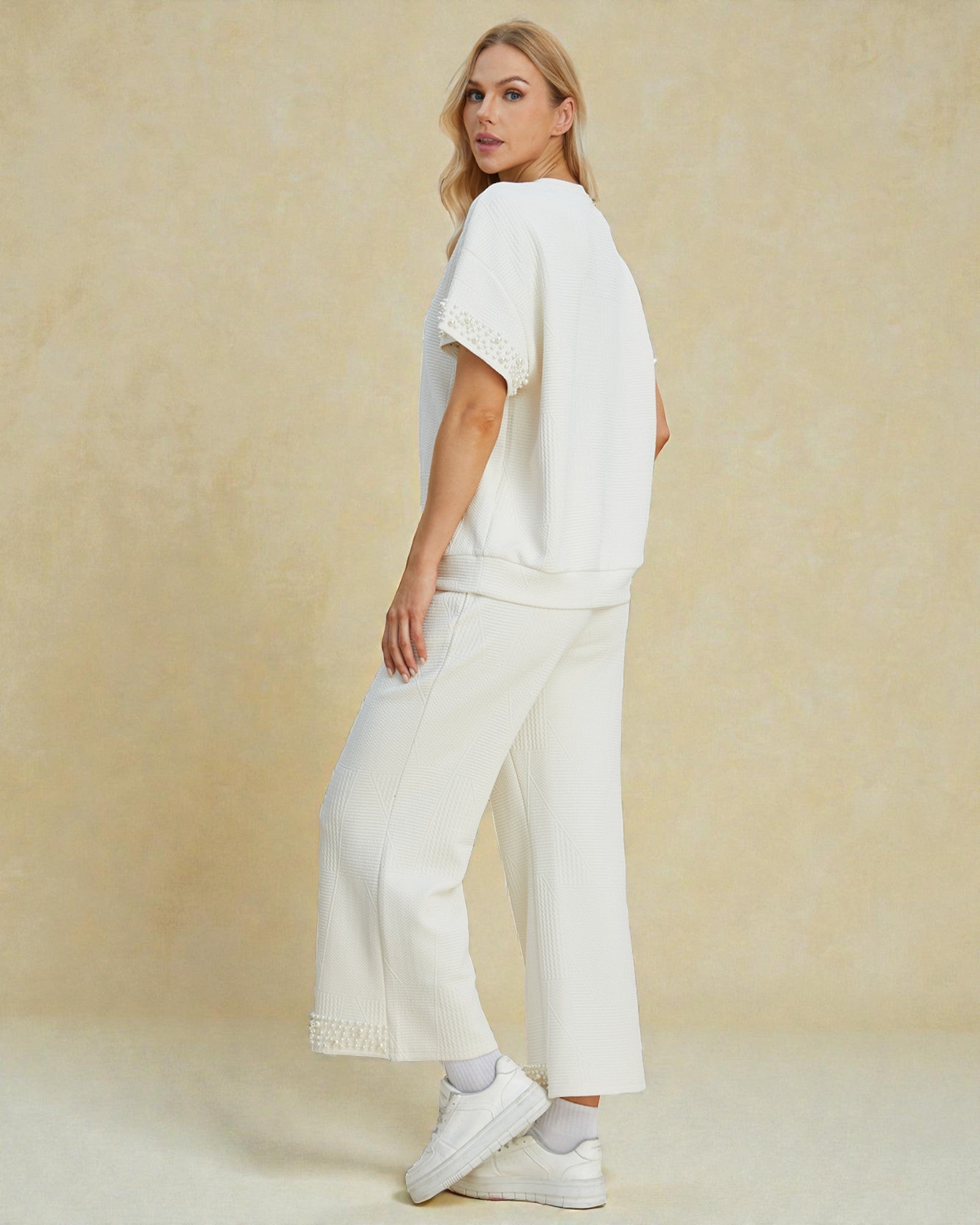 Woman wearing a white outfit with a plain background