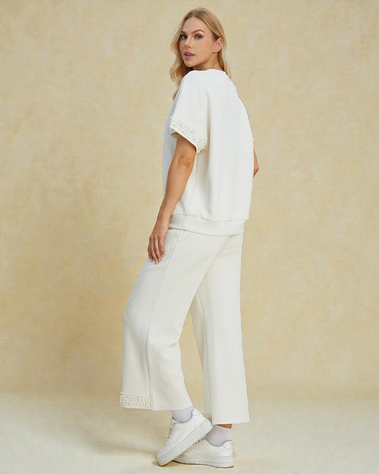 Woman wearing a white outfit with a plain background