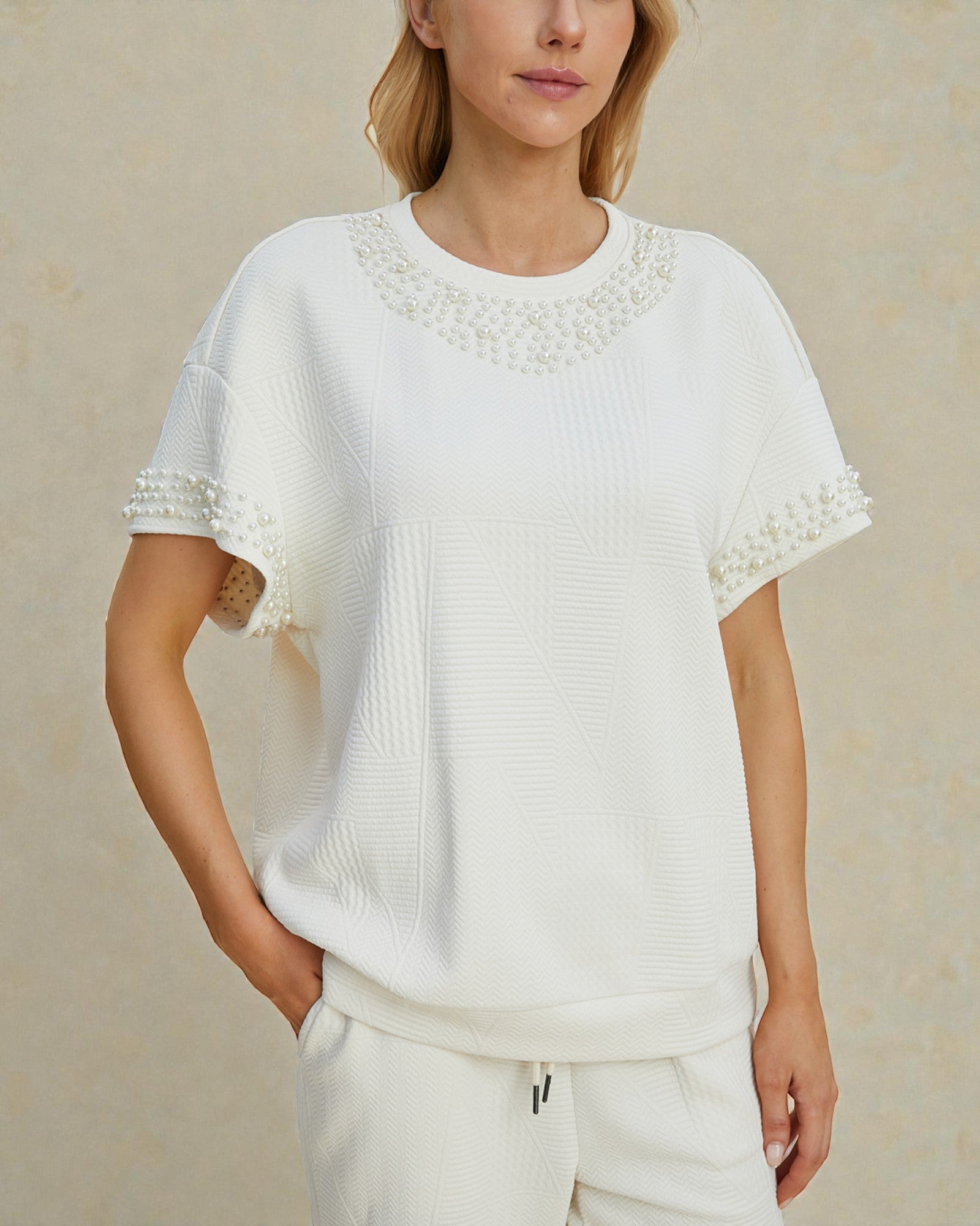 Woman wearing a white blouse with lace details on a beige background