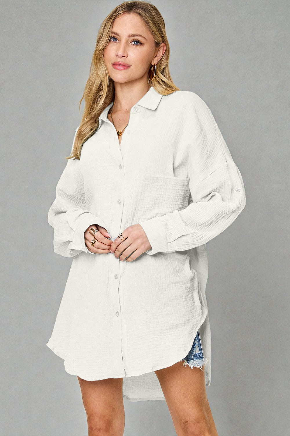Woman wearing a white button-up shirt dress against a gray background
