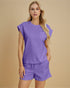 Woman wearing a purple outfit on a beige background