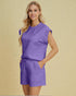 Woman wearing a purple outfit on a beige background