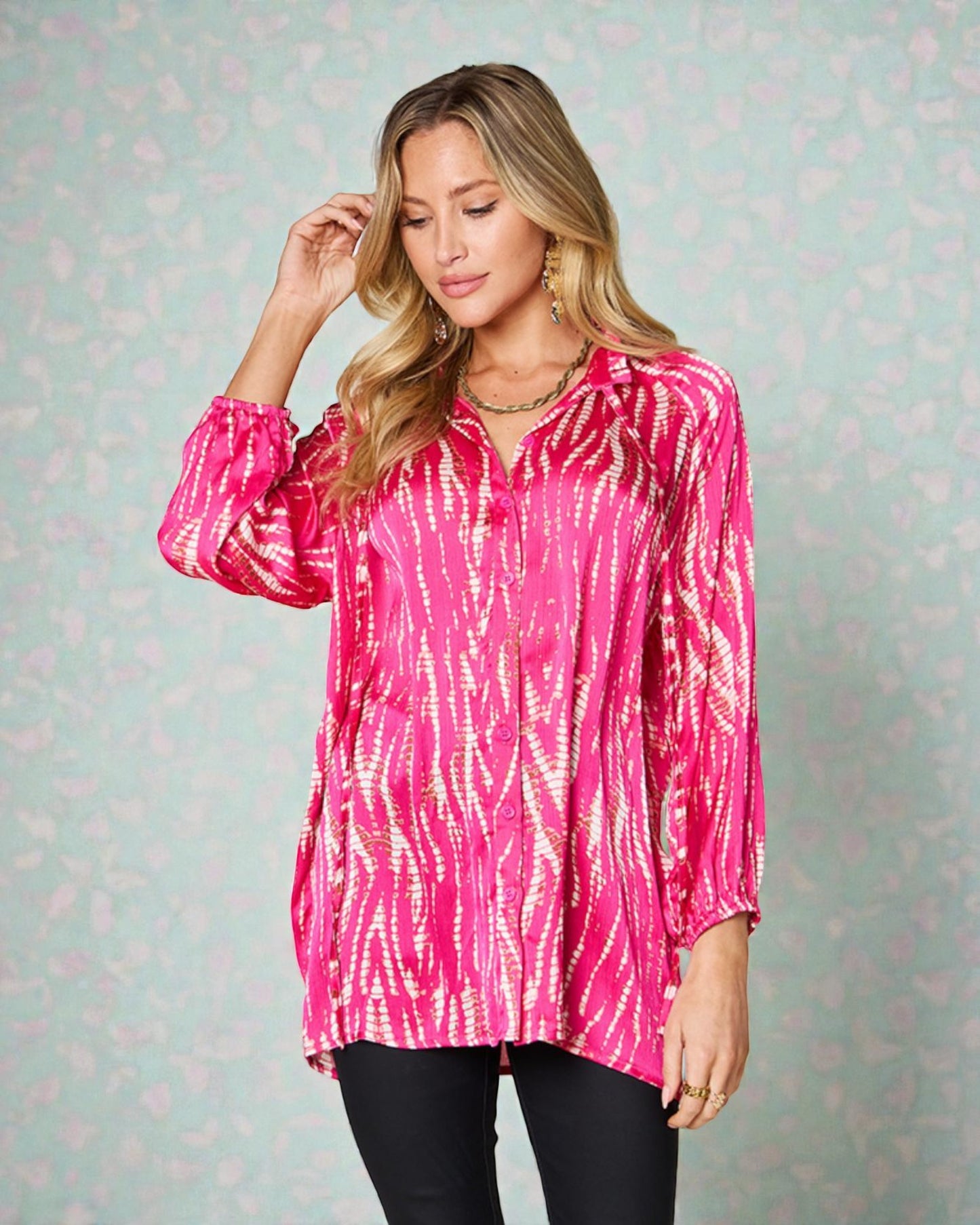 Woman wearing a pink tie-dye shirt against a light patterned background