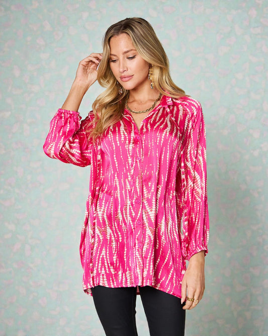 Woman wearing a pink tie-dye shirt against a light patterned background