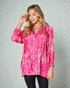 Woman wearing a pink tie-dye shirt against a light patterned background