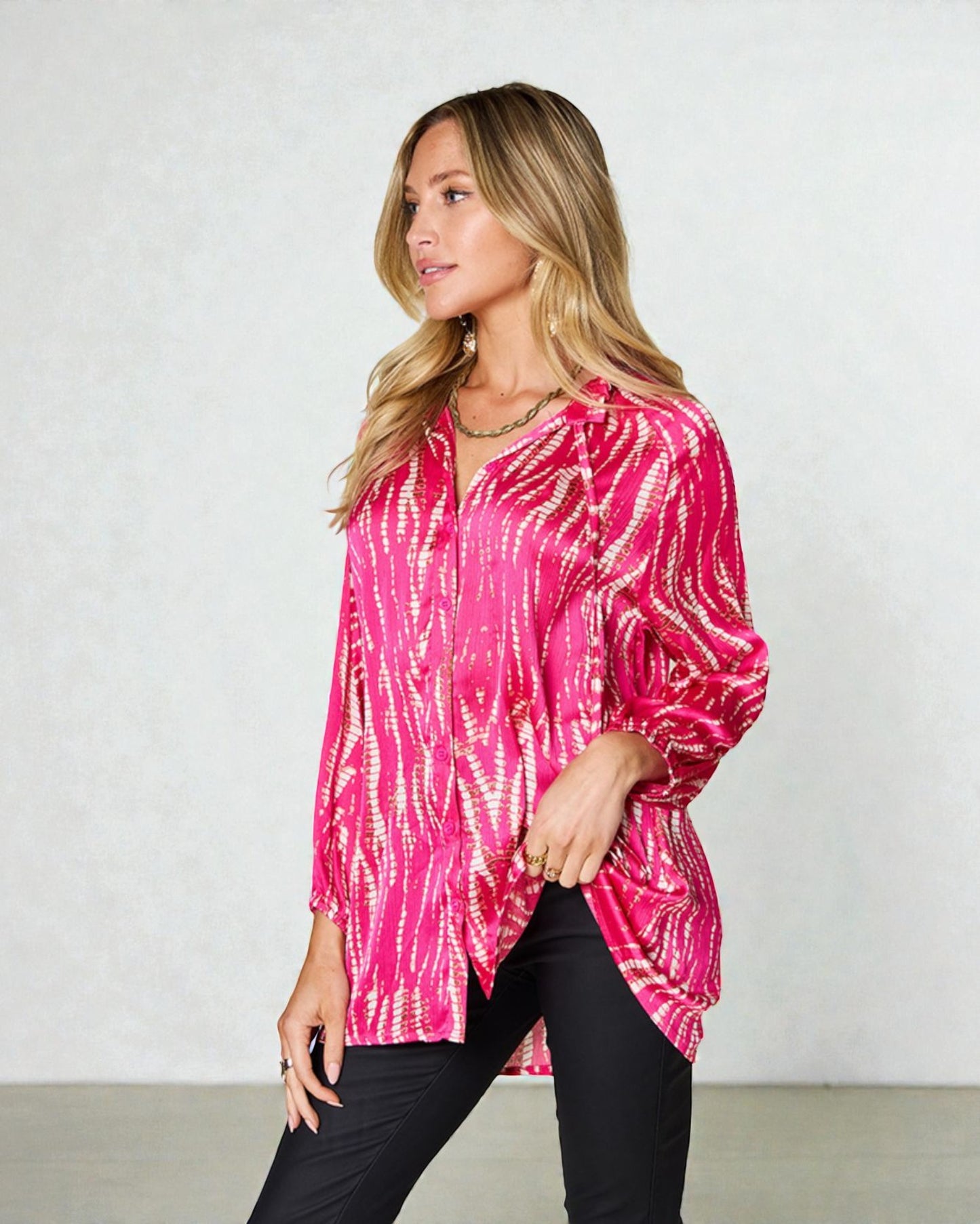 Woman wearing a pink tie-dye shirt against a plain background