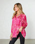 Woman wearing a pink tie-dye shirt against a plain background