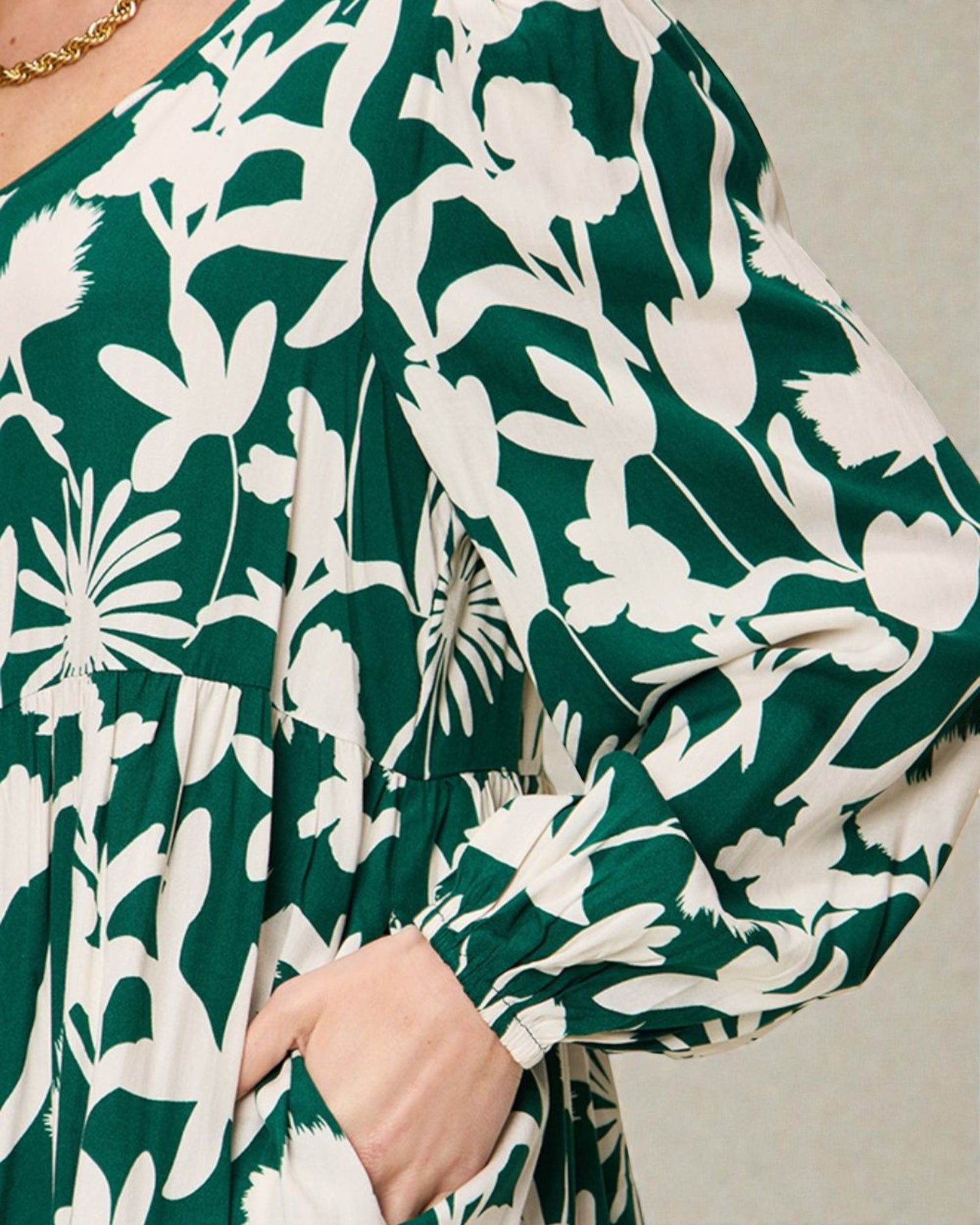 Green dress with white floral pattern worn by a person