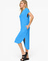 A woman modeling a bright blue midi dress with short sleeves, side cutouts, and a side slit, paired with black platform sandals against a plain white background.