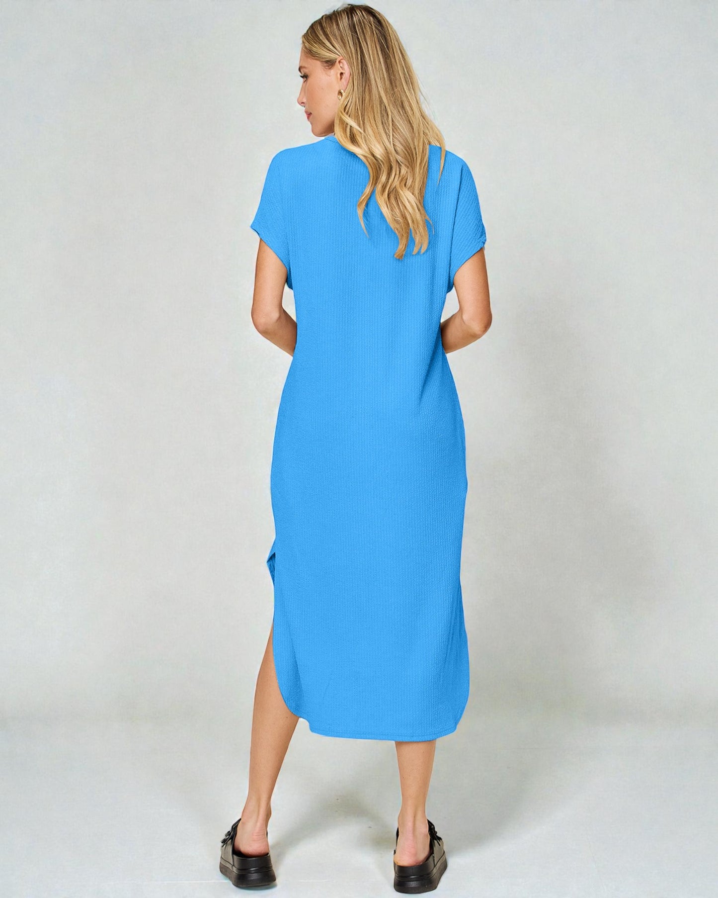 Woman wearing a blue dress against a white background