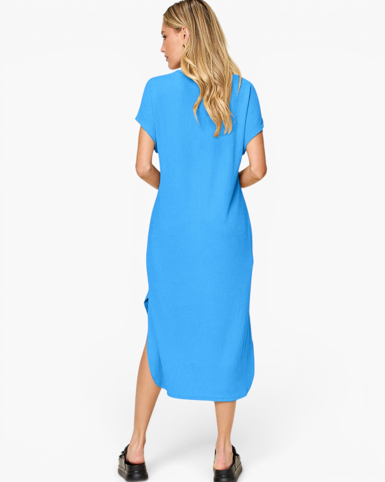 A woman wearing a bright blue short-sleeve midi dress, shown from the back against a plain white studio background.