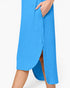 A close-up of a model wearing a bright blue ribbed midi skirt with a side slit and pocket, shown against a plain white background.