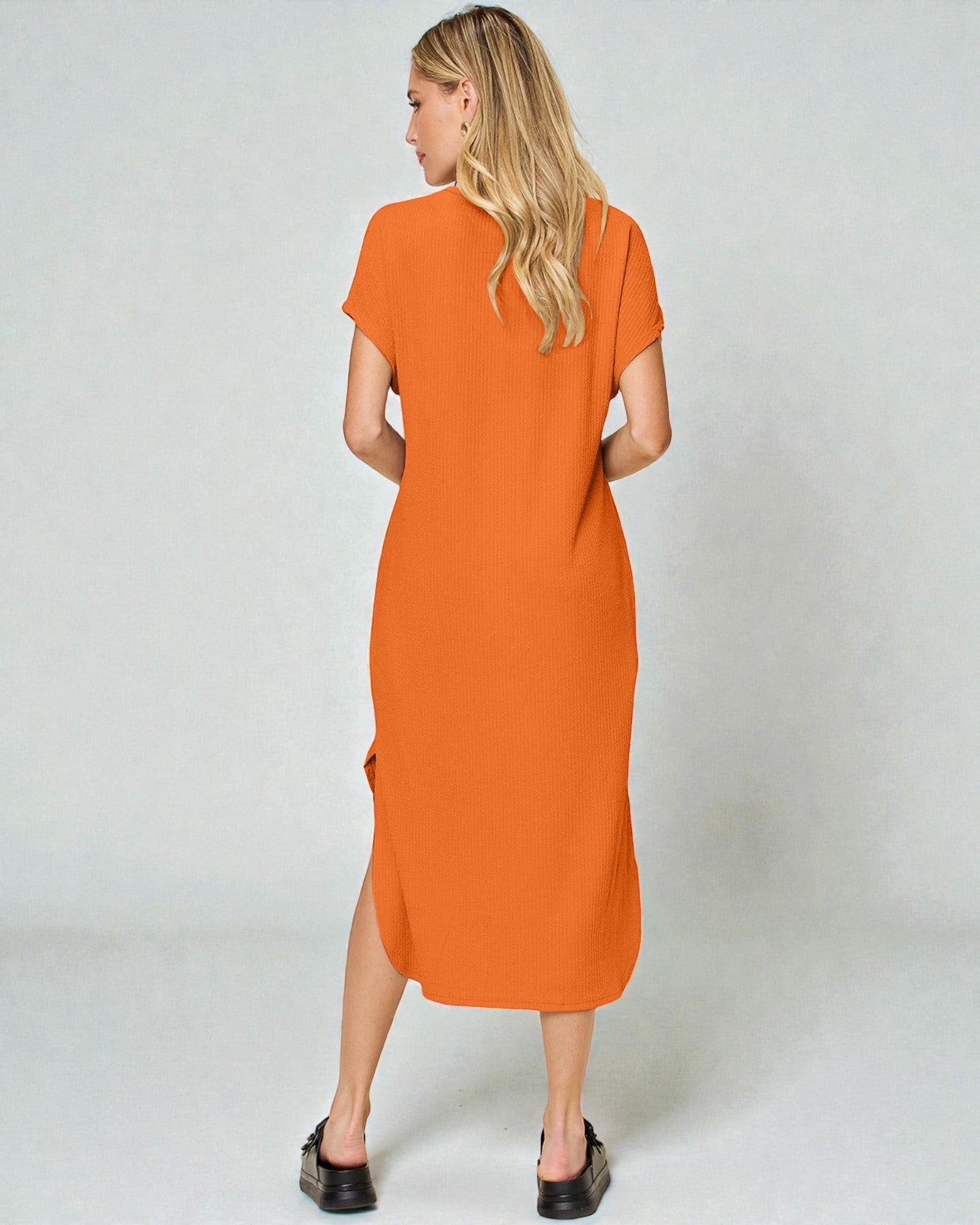 Woman wearing an orange dress against a white background