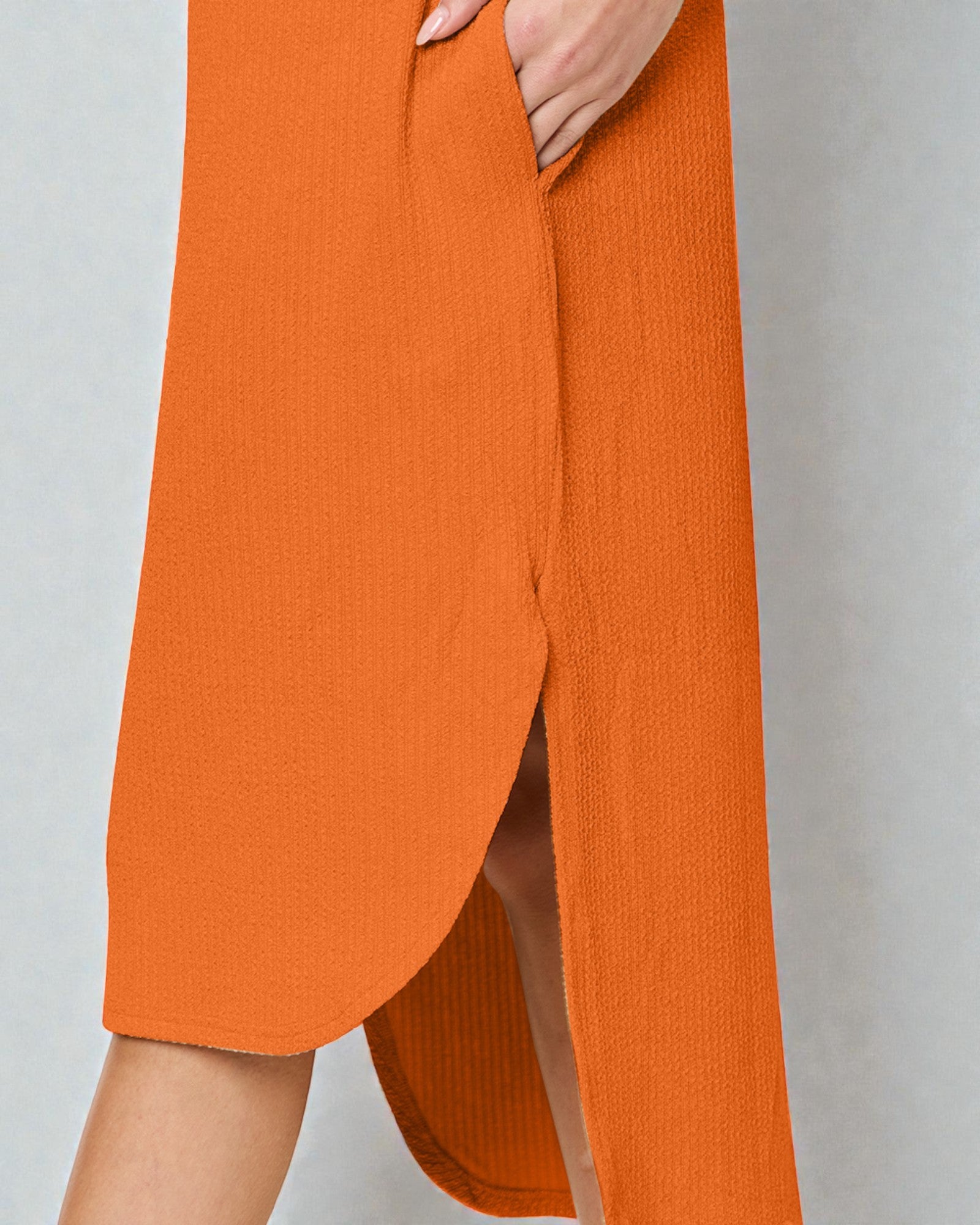 Orange pants with a slit on a plain background