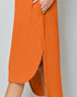 Orange pants with a slit on a plain background